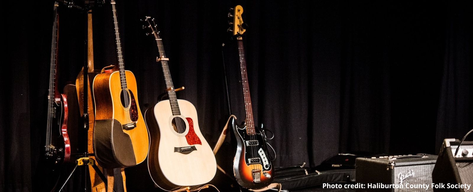 Multiple guitars of different styles on a stage, ready for the musicians.